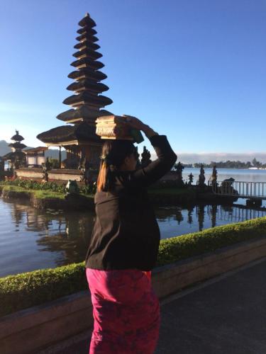 a woman is standing in front of a pagoda at ECO Bedugul adventurer camp in Bedugul