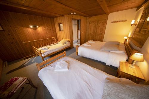 モルジヌにあるLe Châteauの木造キャビン内のベッドルーム1室(ベッド2台付)