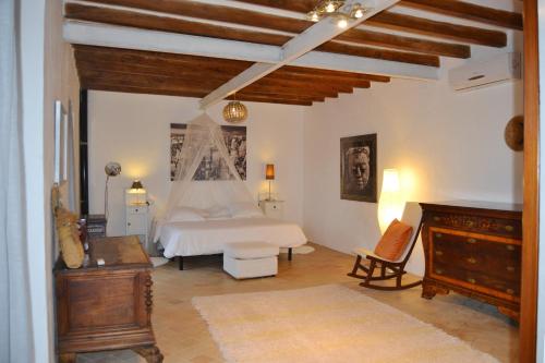 a bedroom with a white bed and a piano at Sa Posada in Estellencs