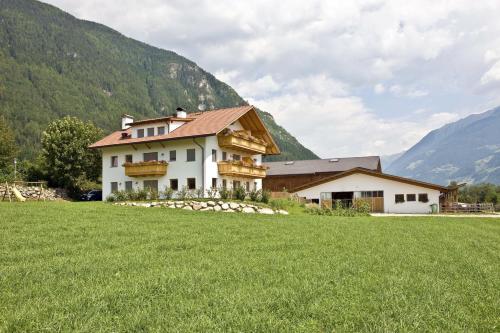 una casa en medio de un campo con montañas en Bartlmairhof, en San Giorgio