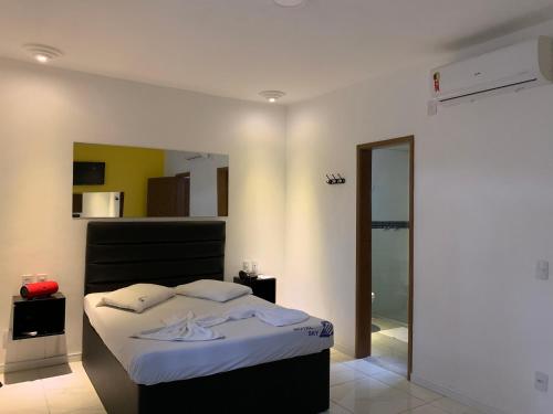 a bedroom with a bed and a door to a bathroom at Motel Sky (Adults Only) in Salvador