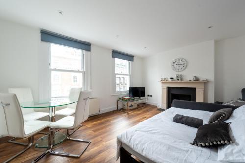 een slaapkamer met een bed en een glazen tafel bij Gorgeous Apartment by Hyde Park (SS4) in Londen