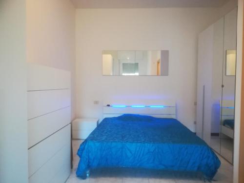 a bedroom with a blue bed and a mirror at Bilocale Marina Romea in Marina Romea