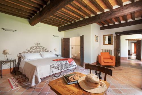 a bedroom with a large bed and a table at Villa Torre degli Elci in Cortona