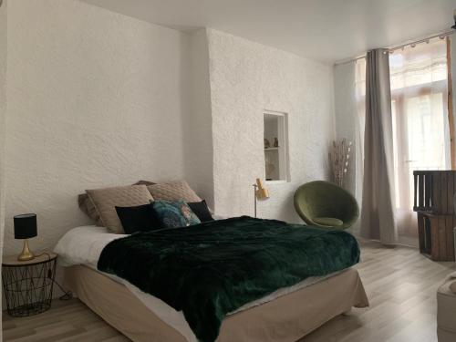 ein Schlafzimmer mit einem Bett mit einer grünen Decke darauf in der Unterkunft Le GREEN & PEACE Centre Historique, en face du musée du Pilori, à 2mn à pied de l'hyper centre et proche toutes commodités, WIFI-Netflix in Niort