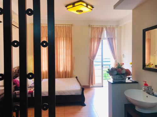 a bedroom with a bed and a sink and a mirror at Khang Homestay in Da Nang
