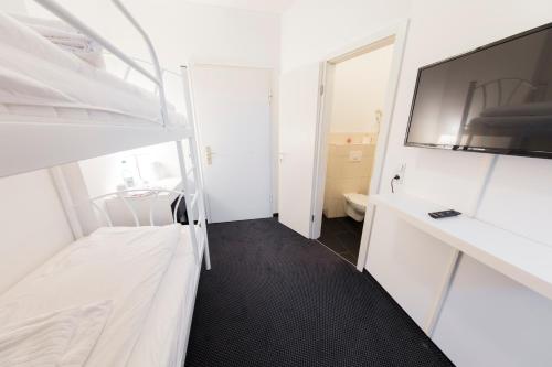 a small white room with a bed and a tv at dreams Düsseldorf in Düsseldorf