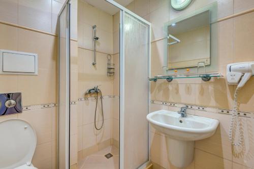 a bathroom with a shower and a sink and a toilet at Hotel Capri in Nesebar
