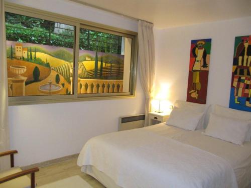 1 dormitorio con cama blanca y ventana en B&B Villa Feline en Cannes