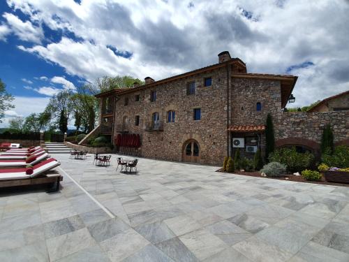 a large brick building with chairs and a patio at Hotel Boutique Puig Francó - Adults Only in Camprodon