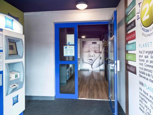 an entrance to a pharmacy with a face on the door at Ibis budget Rouen Petit Quevilly in Le Petit-Quevilly