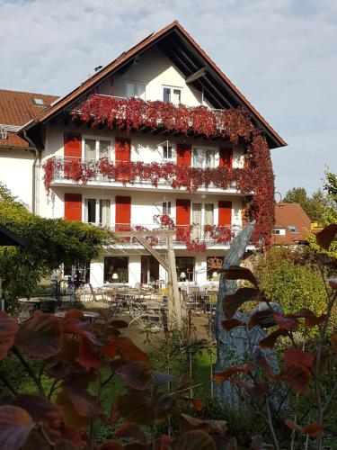a building with a lot of red flowers on it at Hotel KAMPS in Sinsheim