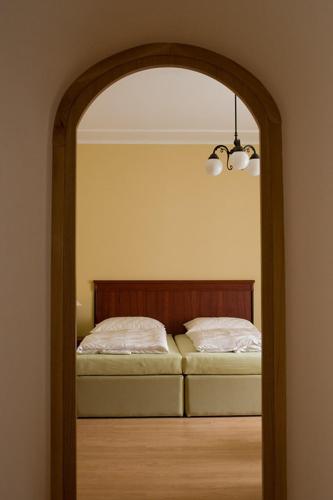 a bedroom with a bed and a mirror in a room at Penzion Zlatý vůl in Znojmo