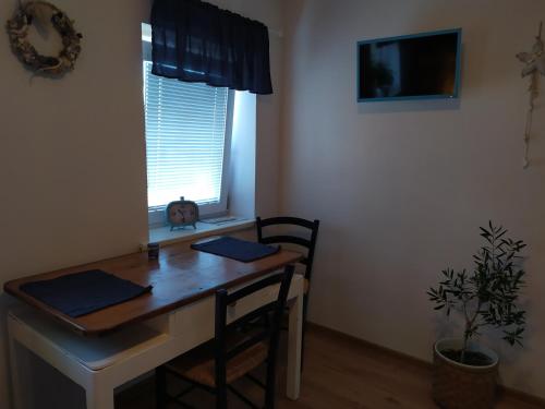 a desk with two chairs and a window with a plant at Pension Skalka in Liberec