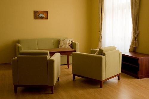 a living room with two chairs and a couch and a table at Penzion Zlatý vůl in Znojmo