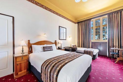 a hotel room with a large bed and a window at Quality Hotel Colonial Launceston in Launceston