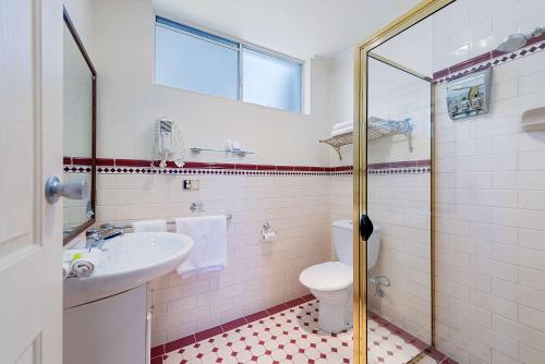 a bathroom with a toilet and a sink at Quality Hotel Colonial Launceston in Launceston