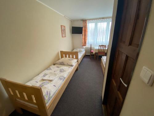 a small room with two beds and a window at Penzion Pod Zámkem in Pruhonice