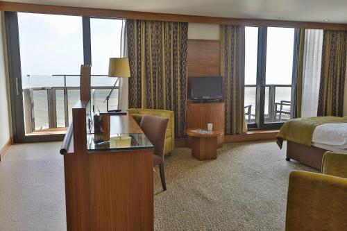 a hotel room with a bed and a desk and a television at The View Hotel in Eastbourne