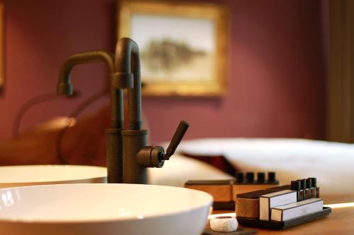 een wastafel in een kamer met een kraan en een kom bij Boutique-Hotel LARTOR in Unterammergau