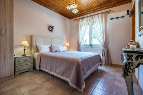 Un dormitorio con una cama grande y una ventana. en Vista Del Mare Luxury Villa, en Koinira