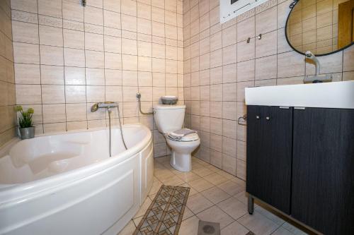 Un baño con bañera, inodoro y lavabo. en Vista Del Mare Luxury Villa, en Koinira