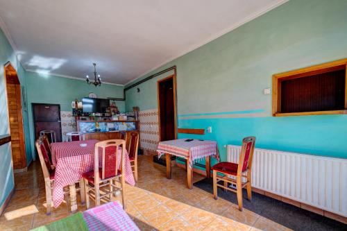 a room with a table and chairs and a kitchen at Guest house Padine Zlatibora in Zlatibor