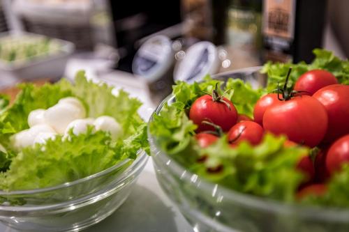two bowls of lettuce and tomatoes on a counter at Hotel Emma Small Luxury Hotel in Florence