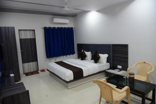 a bedroom with a bed and a desk and a bed sidx sidx sidx at Hotel Savera Palace in Ābu Road