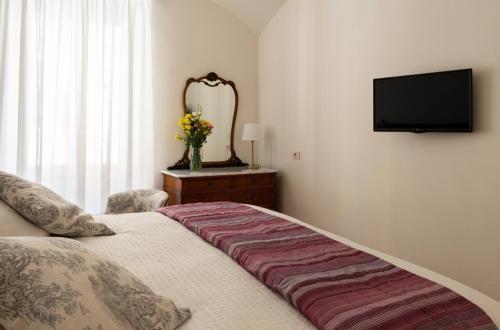 a bedroom with a bed and a mirror and a television at A casa di Rosanna in Rome