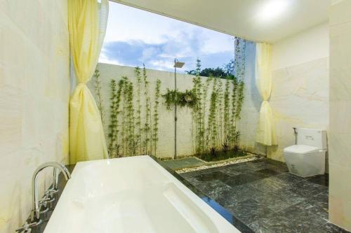 y baño con bañera y aseo. en Hoi An Hideaway Villa, en Hoi An