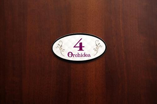 a sign on a wooden door with the number four at Orchidea Rooms & Suites in Civitanova Marche