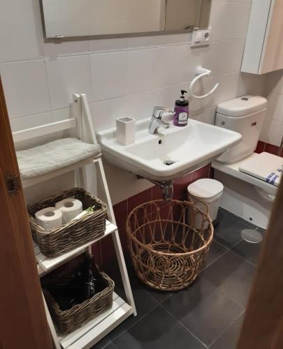 a white bathroom with a sink and a toilet at Apartamento Cine Colón 2 in Ribadeo