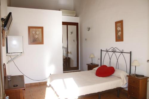 Un dormitorio con una cama con una almohada roja. en Alojamiento Jose Carlos, en Málaga