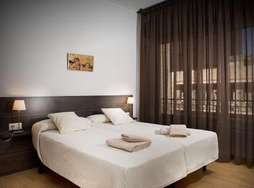 バルセロナにあるClassBedroom Gaudí Apartmentsのベッドルーム1室(大型ベッド1台、タオル付)