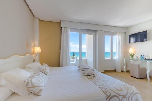 1 dormitorio con 1 cama grande y vistas al océano en Hotel Meridional, en Guardamar del Segura