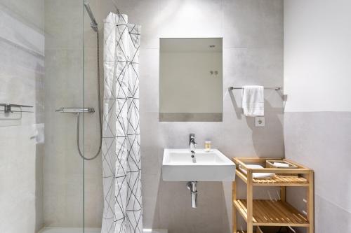 La salle de bains est pourvue d'un lavabo et d'une douche. dans l'établissement ALTIDO Chic studio in Principe Real, nearby Botanical Garden of Lisbon, à Lisbonne