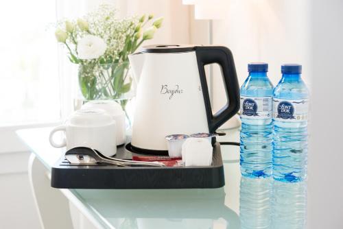 a counter with a coffee maker and two bottles of water at Hotel Meridional in Guardamar del Segura