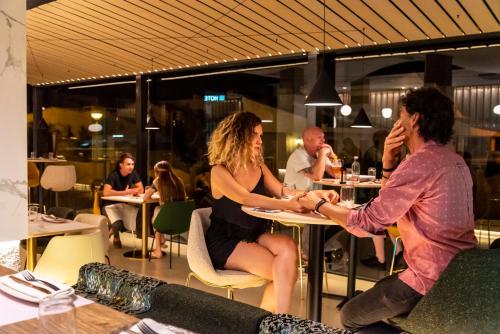 a man and woman sitting at a table in a restaurant at Hotel Meridional in Guardamar del Segura
