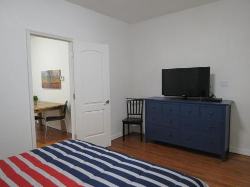 a bedroom with a bed and a television on a dresser at Harding Boutique Apartments in Miami Beach