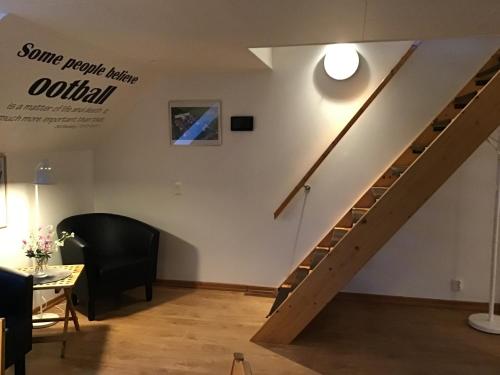 a staircase in a room with a table and a chair at Nordanå Gård in Strö