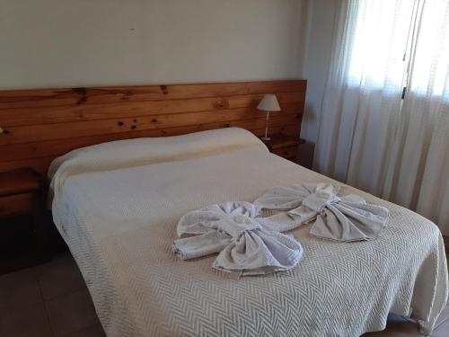 a white bed with towels on top of it at Residencial Sol del Champaqui in Mina Clavero