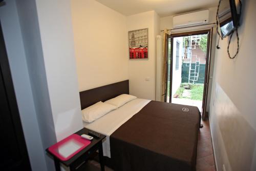 a small bedroom with a bed and a small table at Orchidea Rooms & Suites in Civitanova Marche