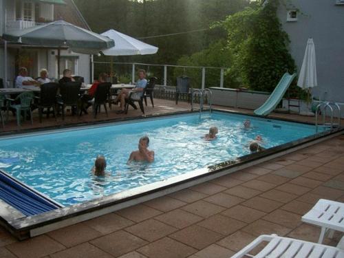 a group of people swimming in a swimming pool at Möllegården Bed & Breakfast in Tyringe