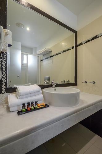 a bathroom with a sink and a large mirror at Aeolis Boutique Hotel in Naxos Chora