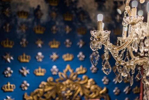 a gold chandelier in front of a blue wall at Valletta Lucente Guest House in Valletta