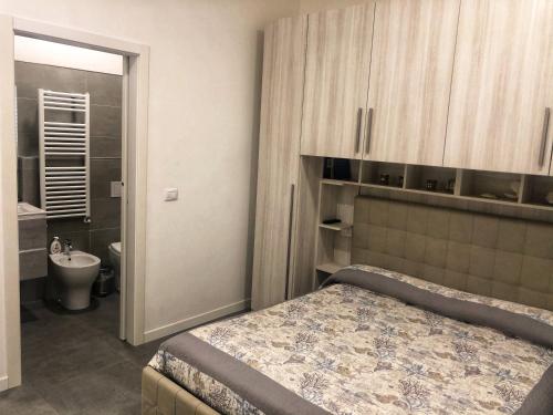 ein Schlafzimmer mit einem Bett und ein Badezimmer mit einem Waschbecken in der Unterkunft B&B Il Corallo in San Benedetto del Tronto