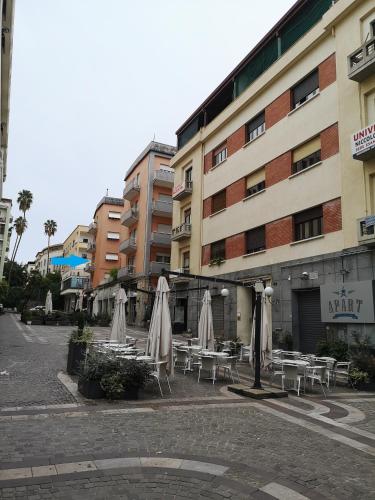 a group of tables and umbrellas in front of a building at Brutia Mom&Son in Cosenza