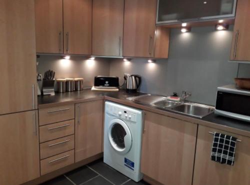 a kitchen with a washing machine and a sink at Beachview Apartment in Edinburgh