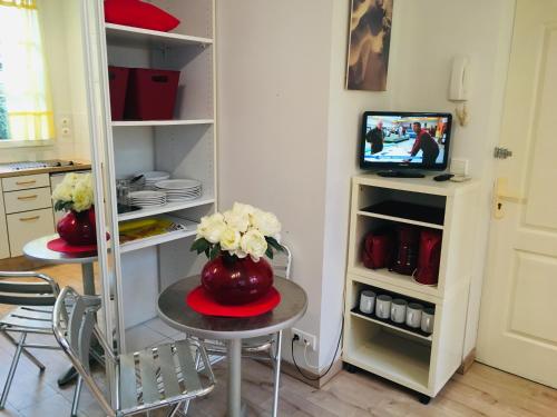 une pièce avec une table avec un vase de fleurs dessus dans l'établissement studio EMILY, à Cannes